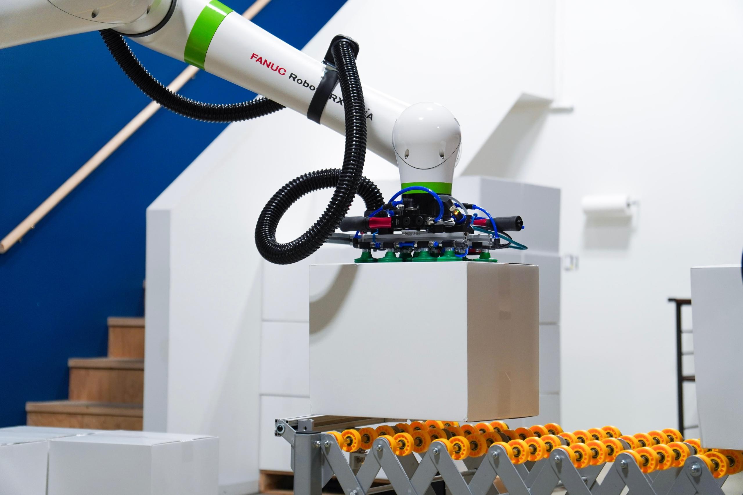 Robot end of arm tool grabbing a box.